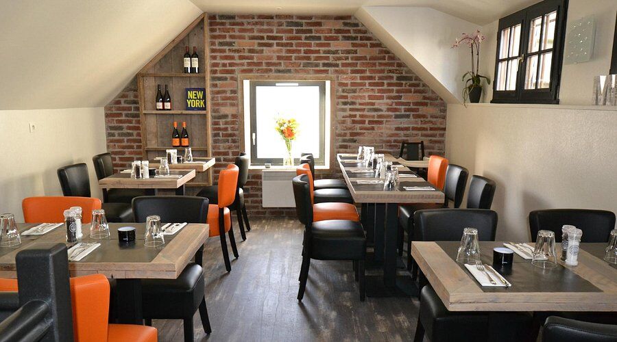 Saal des Restaurants Midtown, orangefarbene Sessel und Ziegelwand